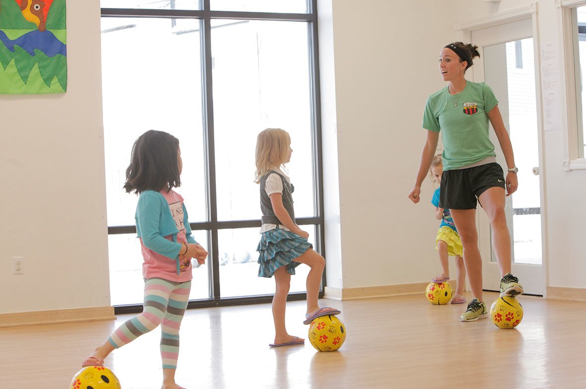 children playing soccer in an indoor gym