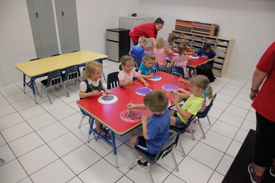 children at a table working on projects